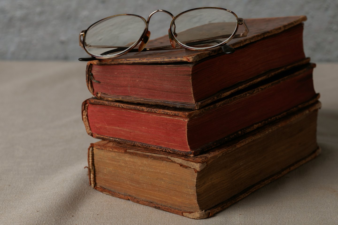 Antique reading glasses sit on old books.